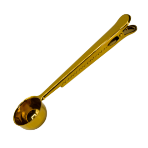 Cuchara con pinza integrada en acabado dorado sobre fondo blanco